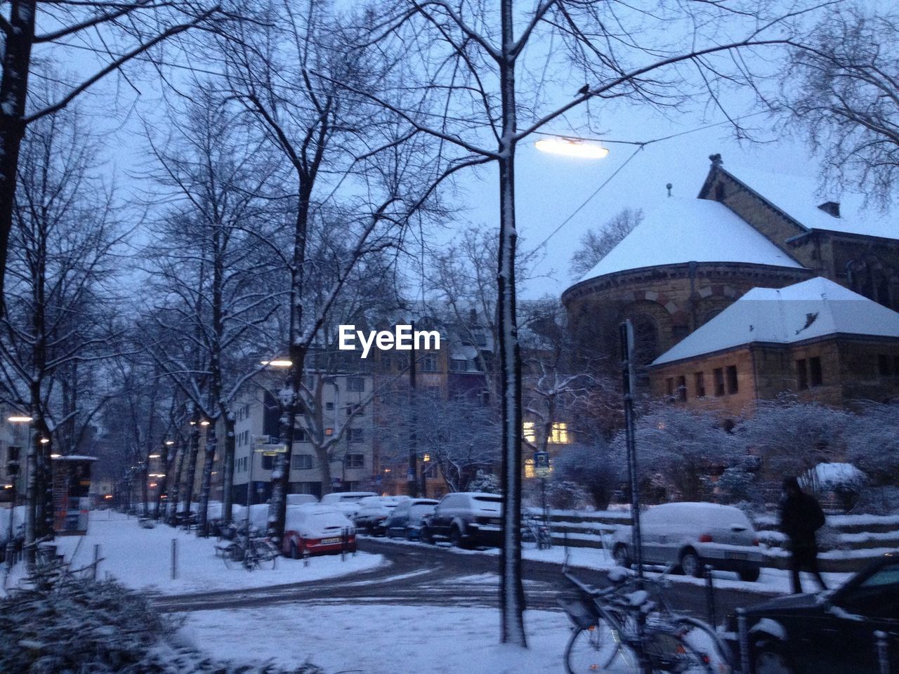 A pedestrian walks down a snowy street