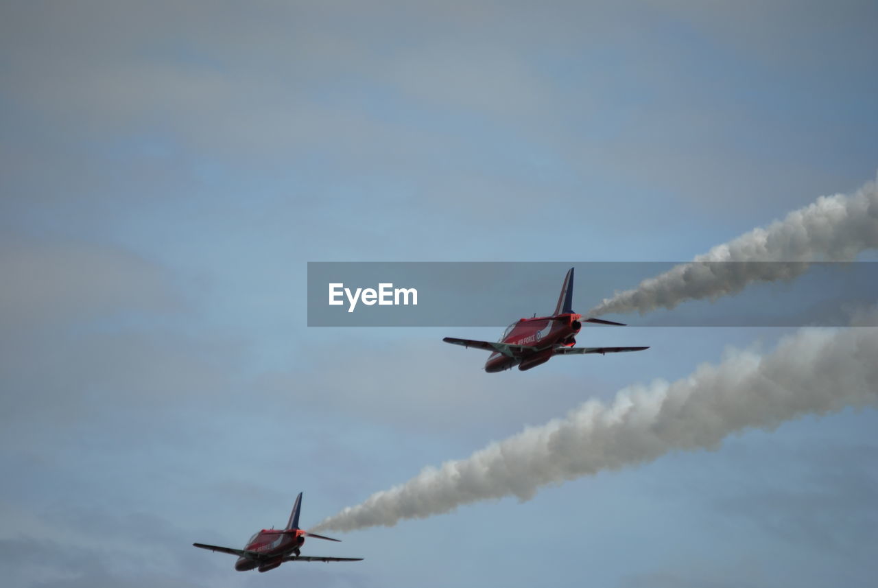 Low angle view of airshow against sky