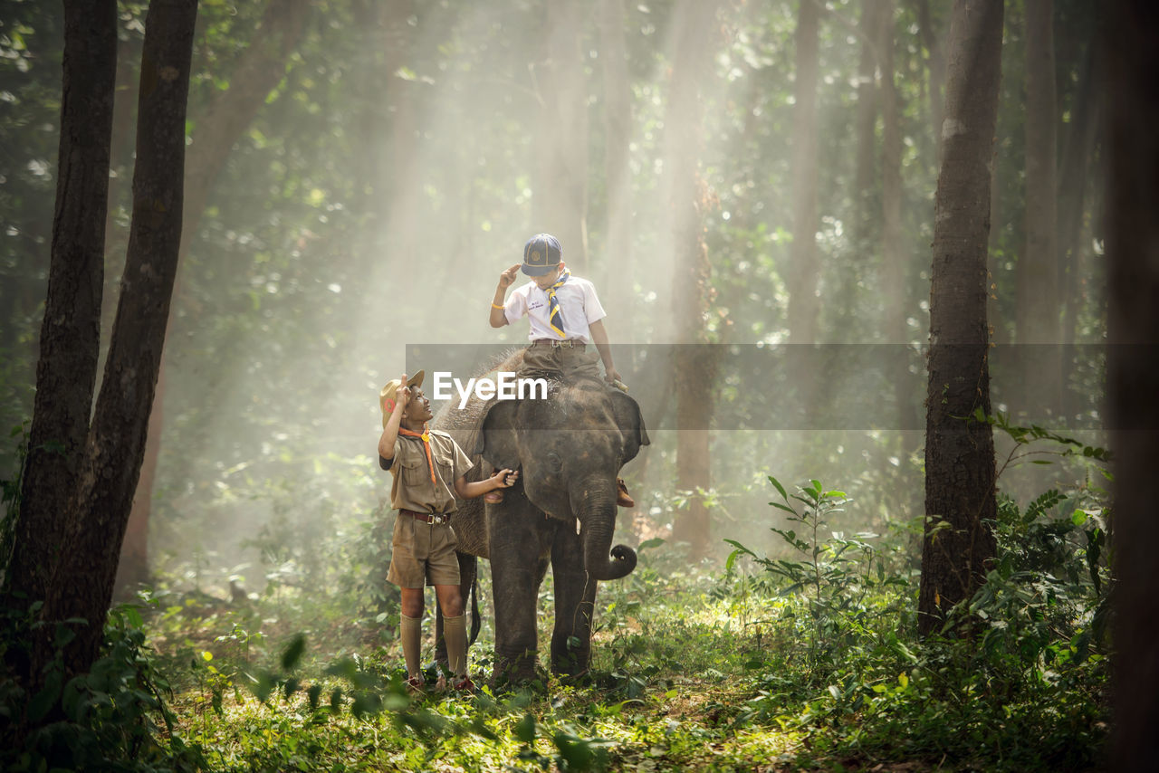 YOUNG MAN RIDING MOTORCYCLE ON TREE TRUNK