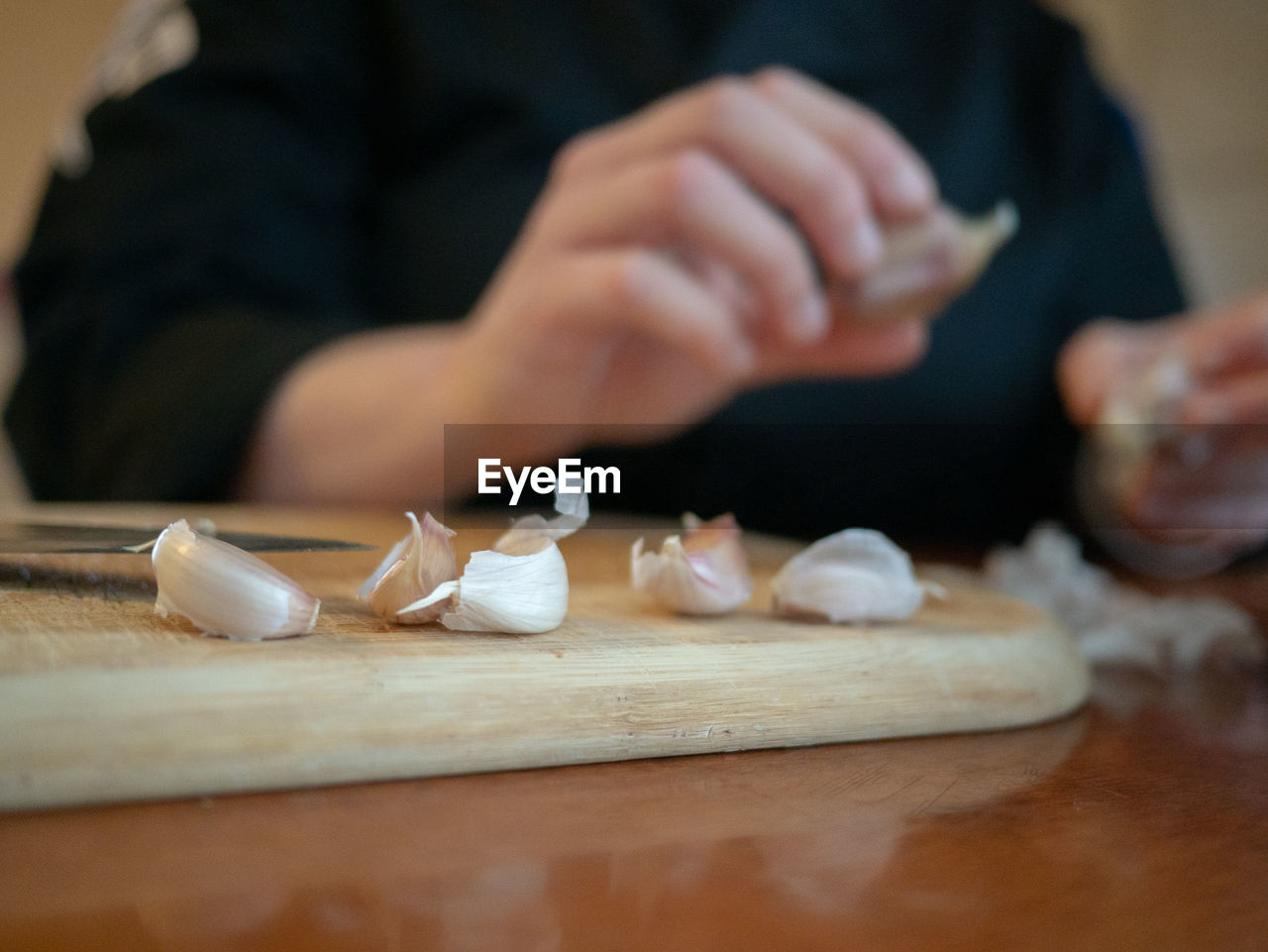 Midsection of person preparing food on cutting board at home