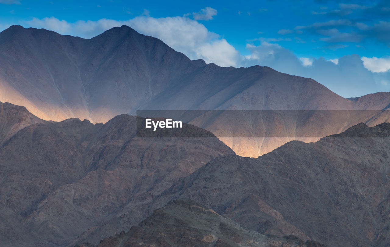 Scenic view of mountains against cloudy sky