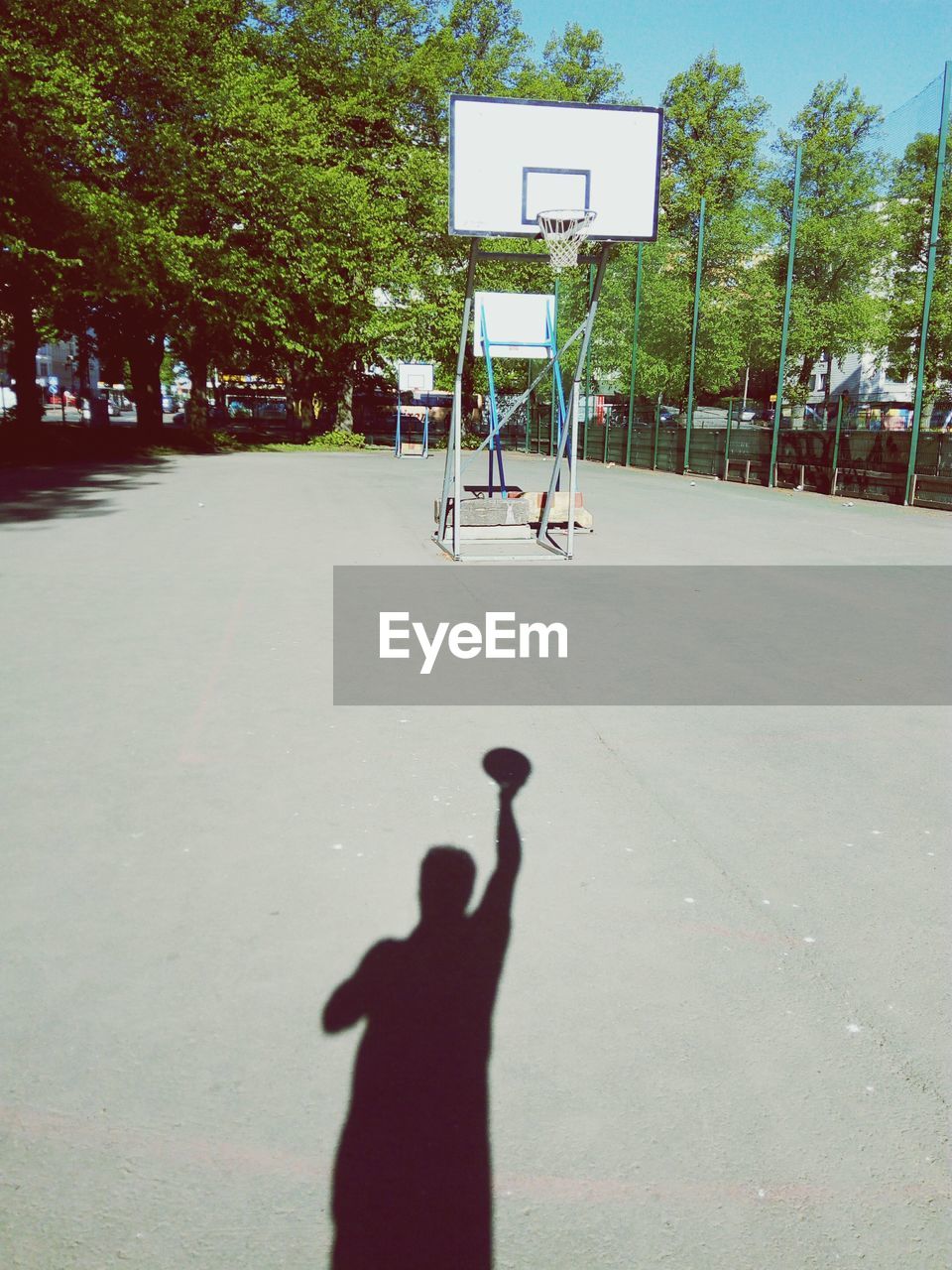 SHADOW OF BASKETBALL HOOP ON COURT