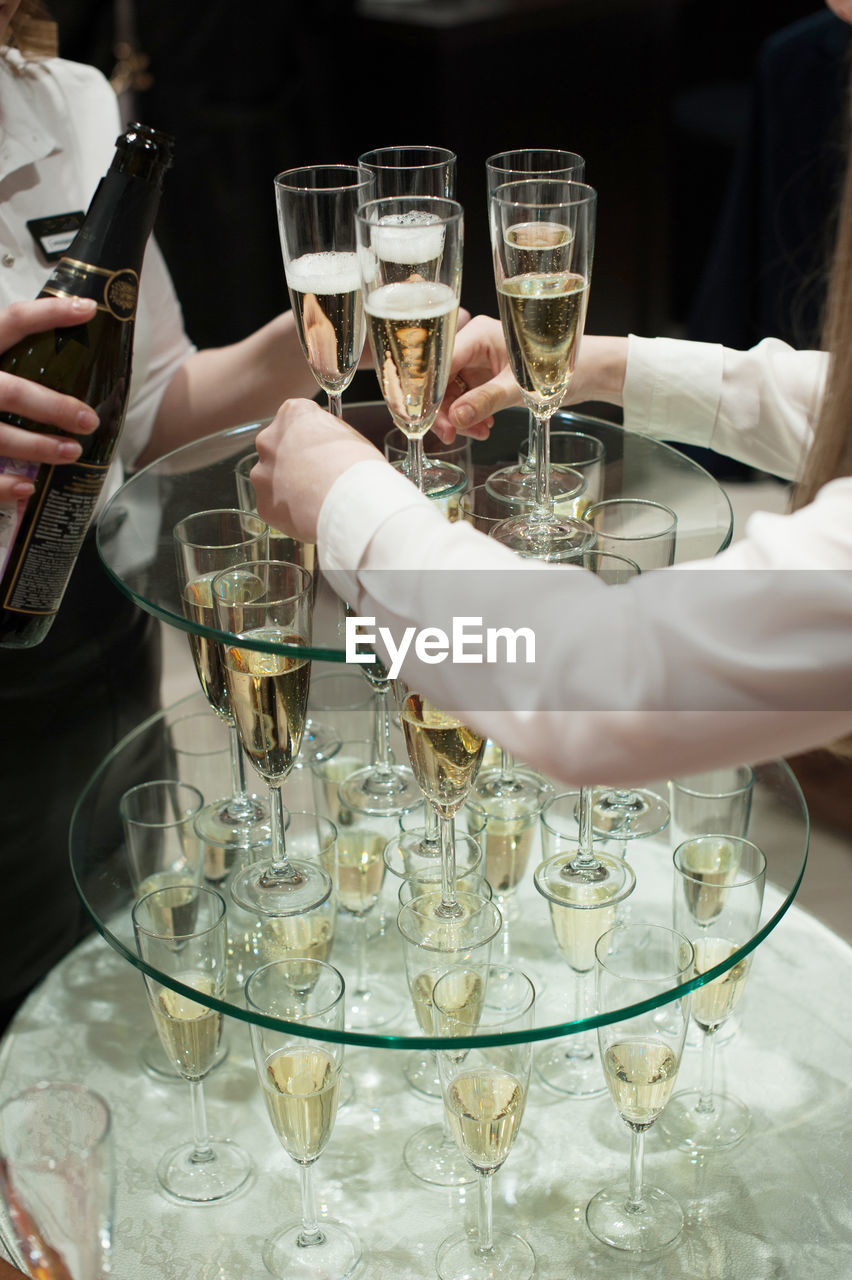 Cropped hands holding champagne flute table