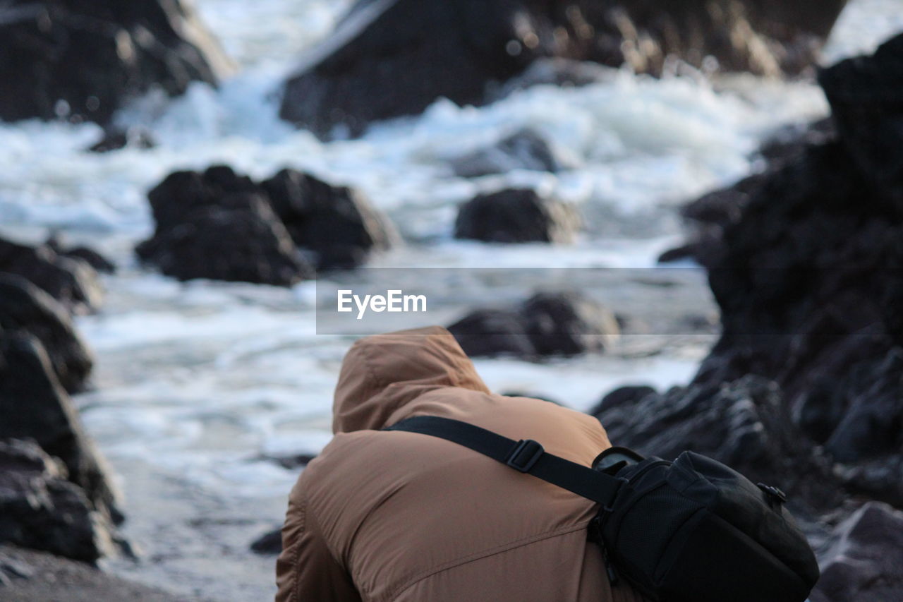 Rear view of man sitting on land during winter