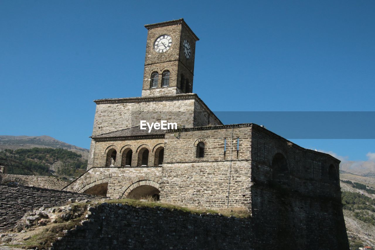 architecture, built structure, building exterior, history, tower, sky, building, clock, the past, place of worship, travel destinations, religion, blue, clear sky, nature, bell tower, belief, no people, spirituality, travel, landmark, day, time, sunny, clock tower, tourism, outdoors, ancient history, wall, old, sunlight, low angle view, fort, fortified wall, historic site