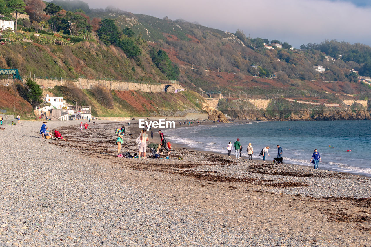 body of water, land, sea, beach, water, coast, group of people, shore, nature, large group of people, crowd, bay, holiday, travel, sky, vacation, mountain, trip, environment, tourism, travel destinations, sand, scenics - nature, leisure activity, landscape, tourist, lifestyles, men, coastline, outdoors, beauty in nature, summer, architecture, day, adult, tree, ocean, women