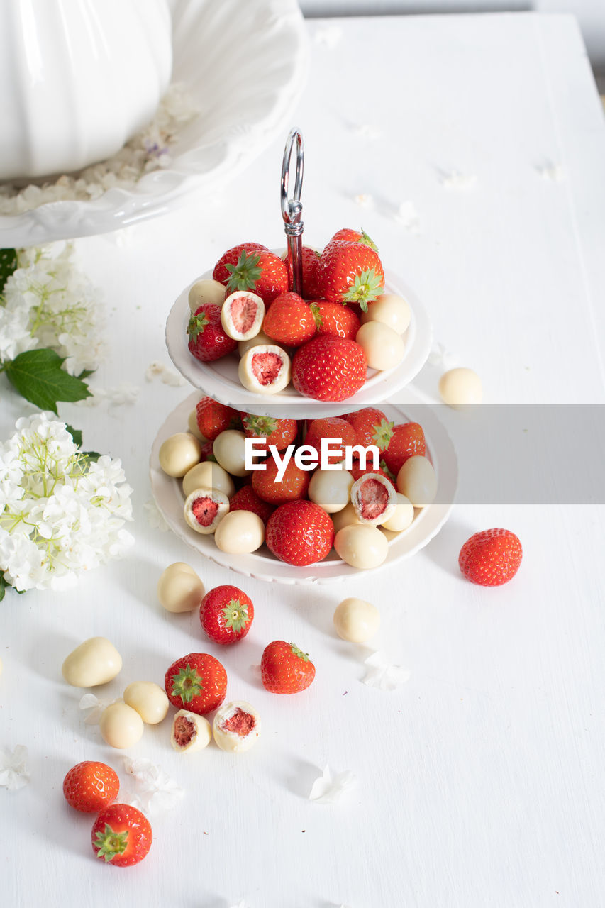 White chocolate covered strawberries, fresh strawberries and white floweers