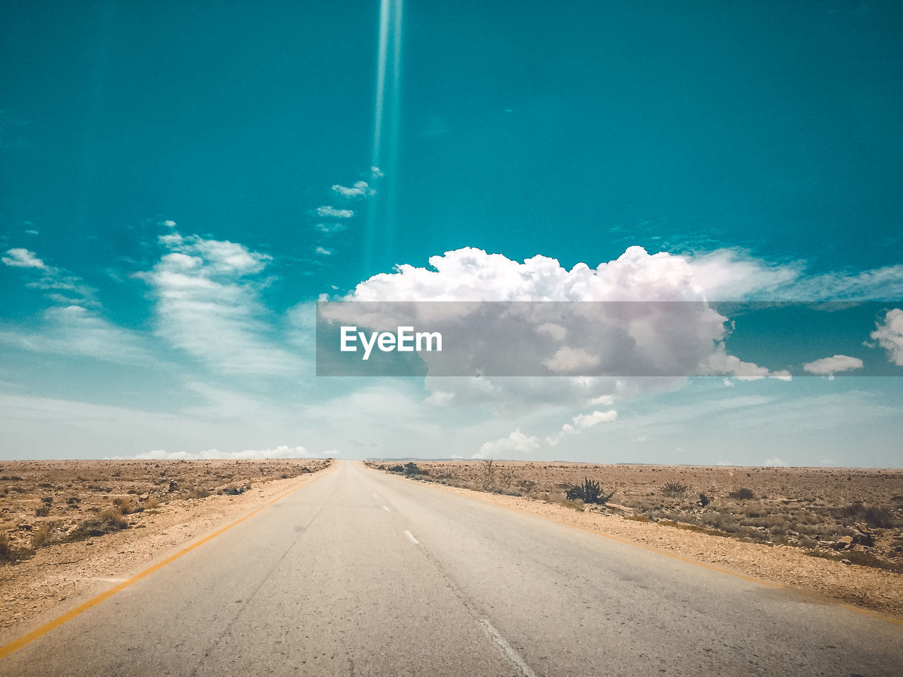 ROAD AMIDST LAND AGAINST SKY