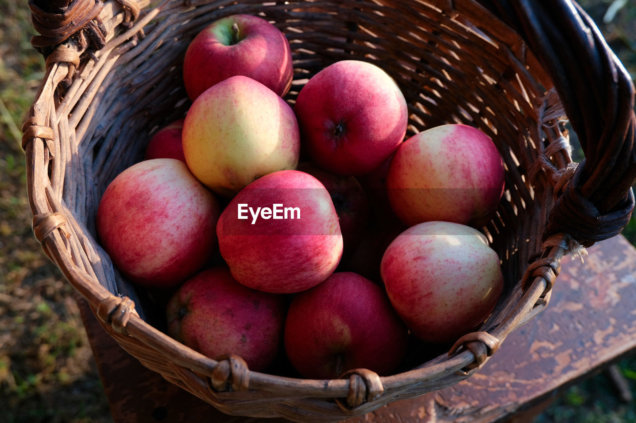 An old wicker basket with red ripe apples