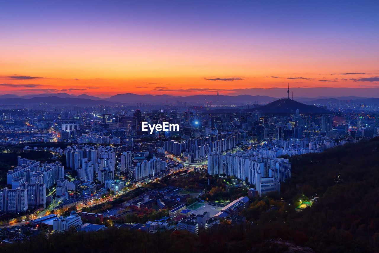 High angle view of illuminated buildings against sky at sunset