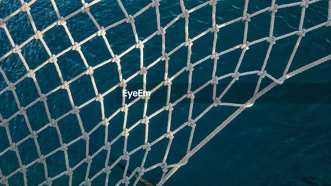 Close-up of net against sea