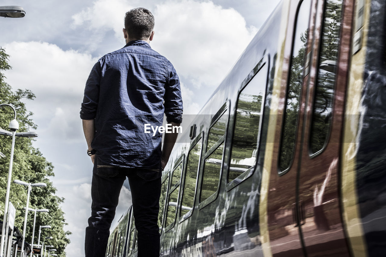 Rear view of man standing by train