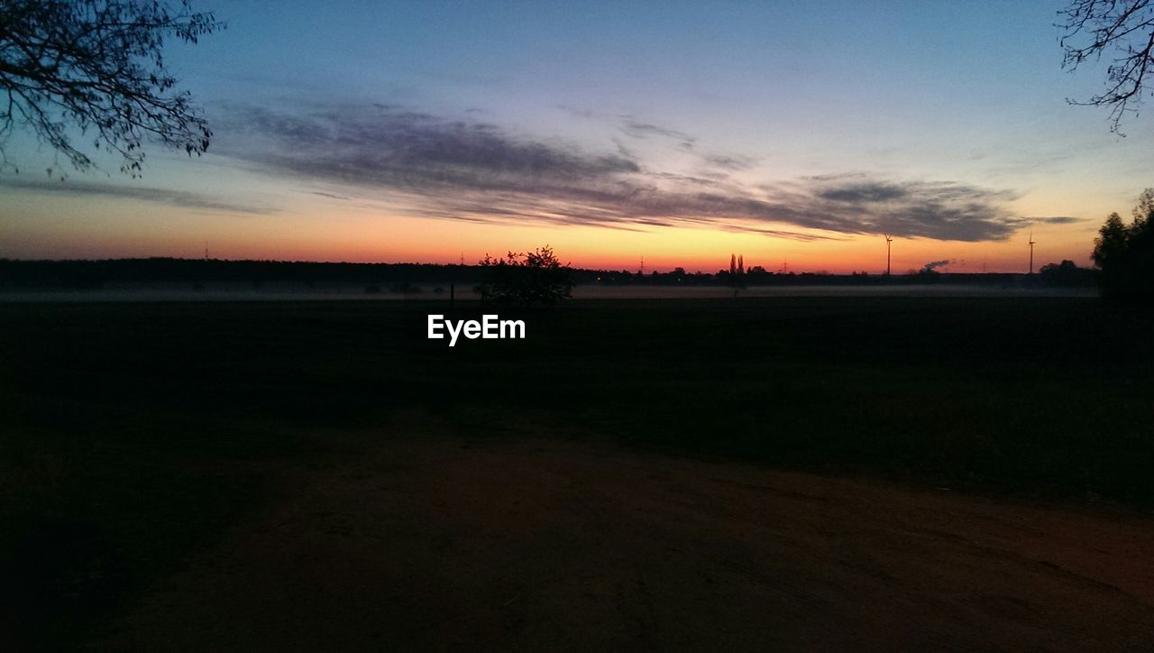 SCENIC VIEW OF FIELD AGAINST SKY DURING SUNSET