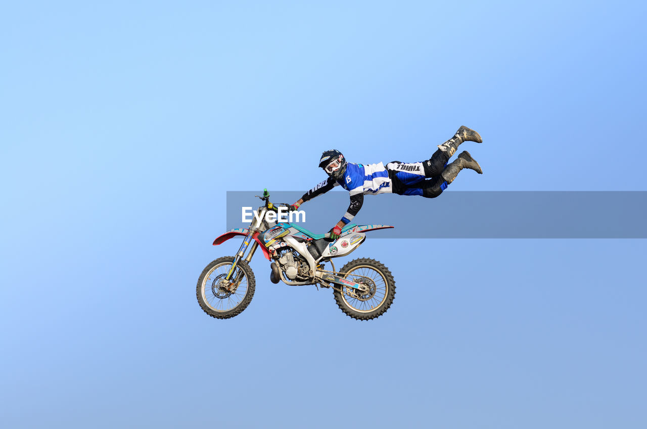 LOW ANGLE VIEW OF MAN RIDING MOTORCYCLE AGAINST SKY