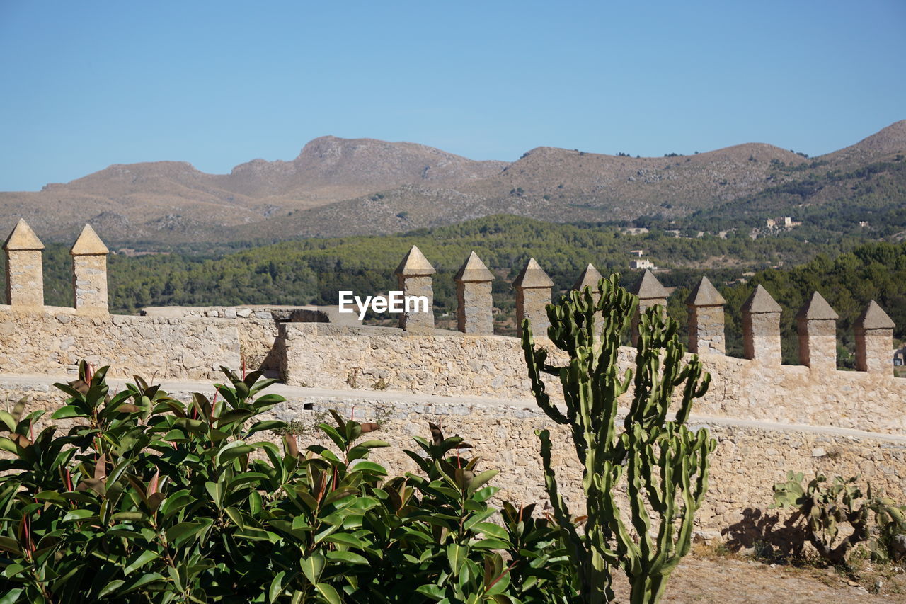 Low angle view of fort and mountains against sky