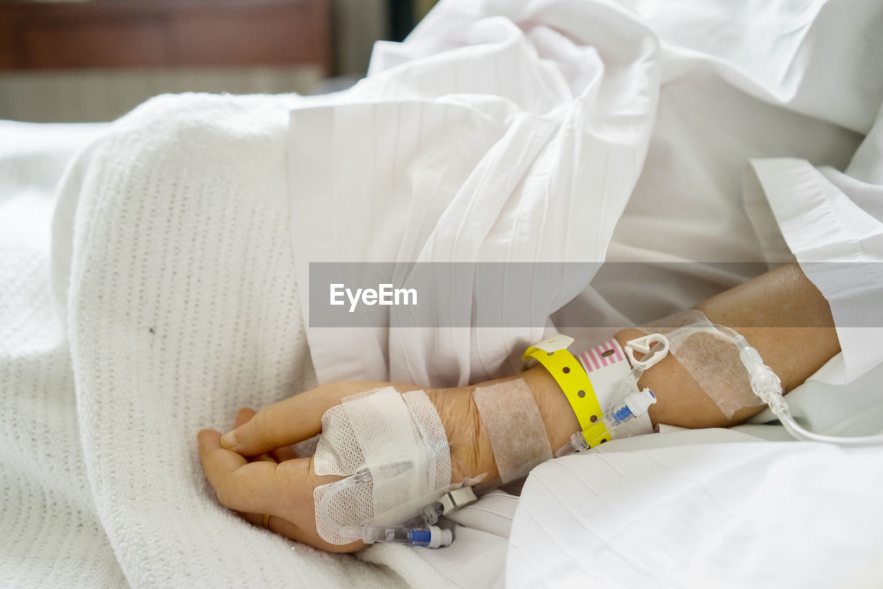 Midsection of patient wearing iv drip in hospital