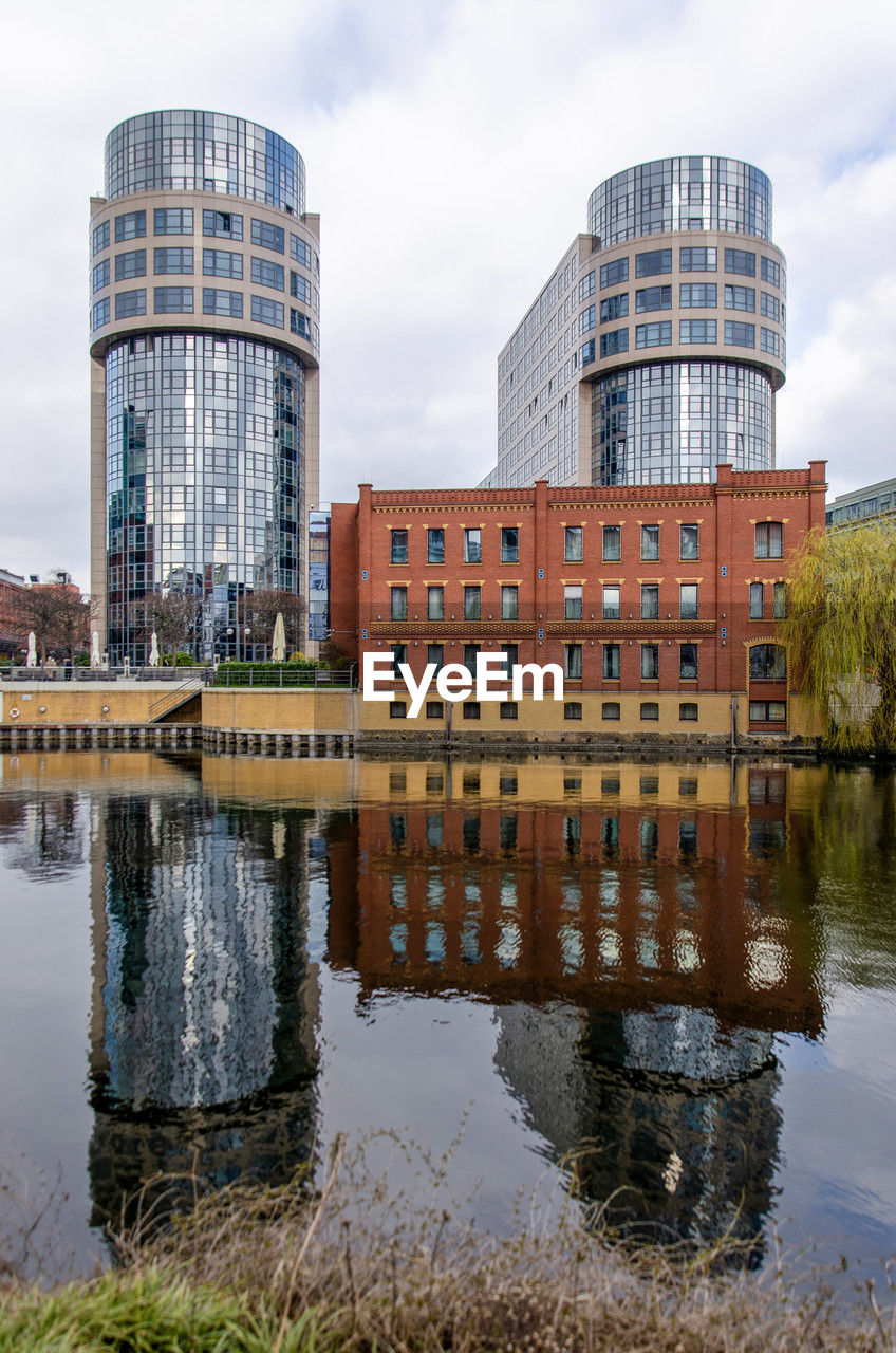 Traditional building with a brick facade and two buildings with reflective glass facades