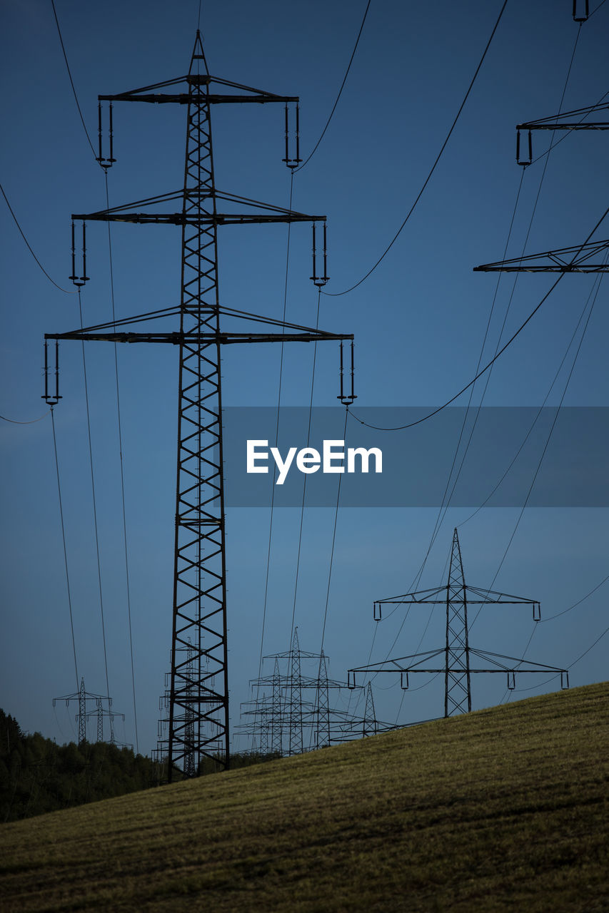 LOW ANGLE VIEW OF ELECTRICITY PYLON ON LAND AGAINST SKY