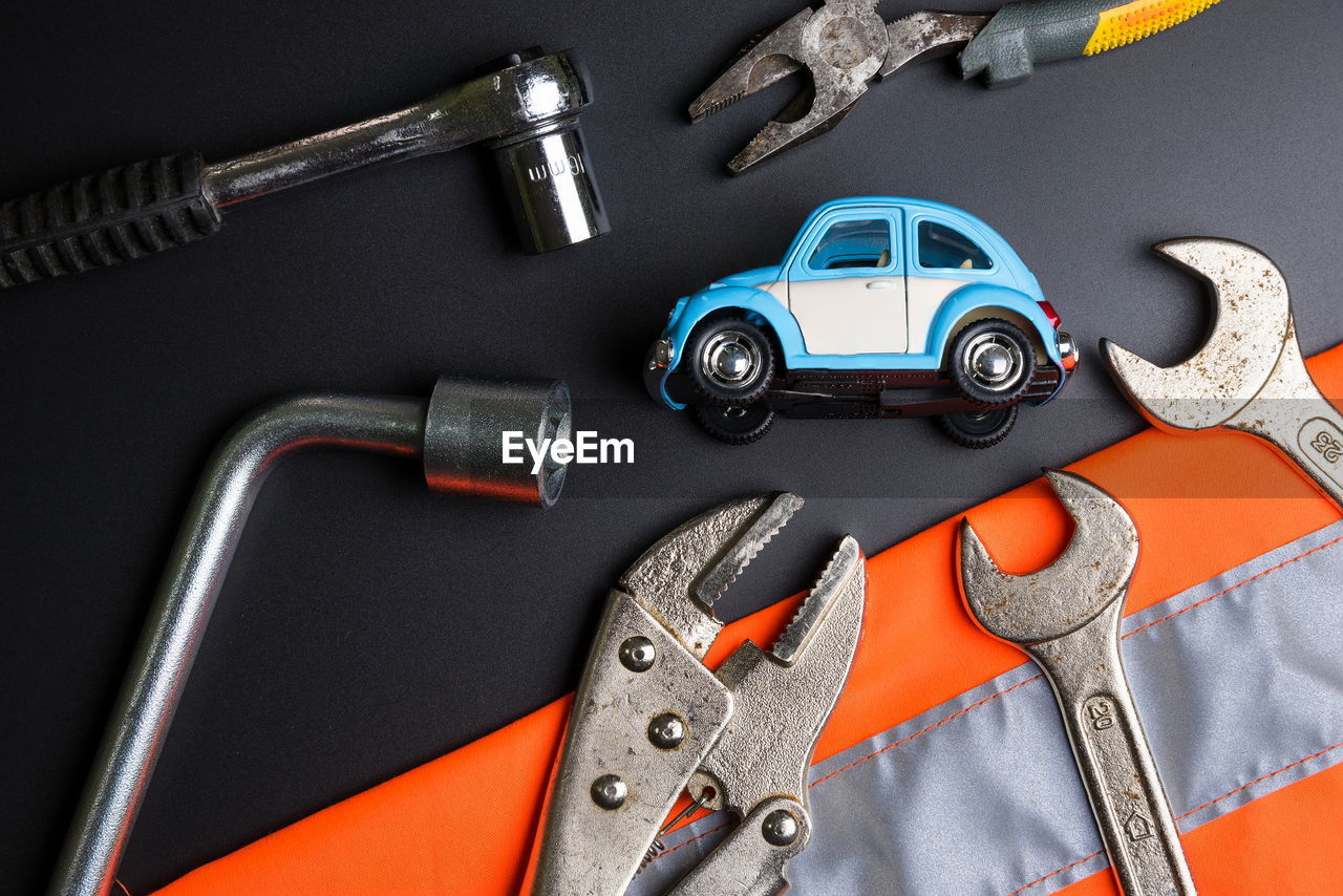 High angle view of toy car with hand tools on table