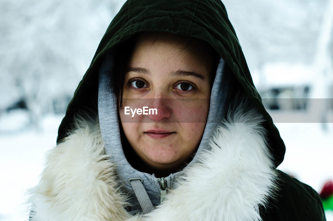 Portrait of young woman sitting outdoors during winter