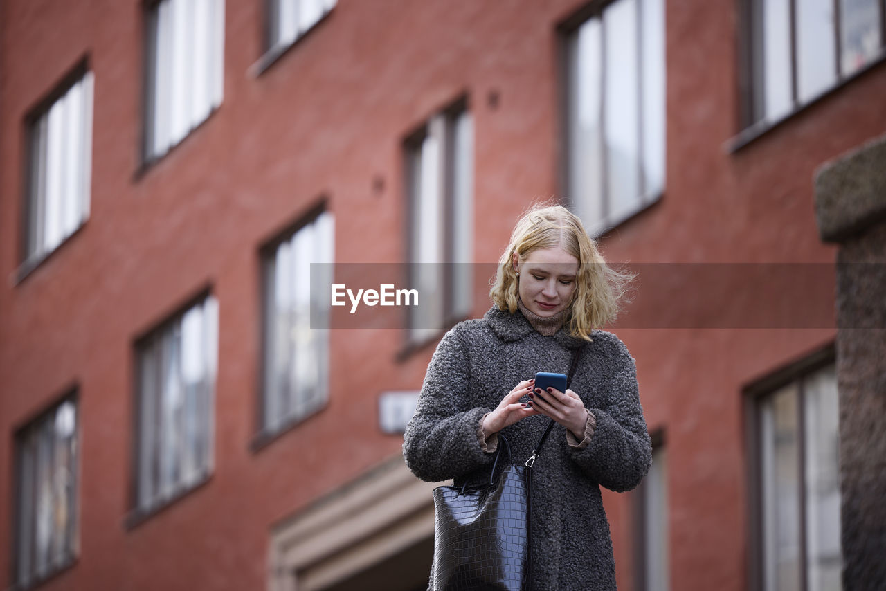 Woman using her cell phone while walking