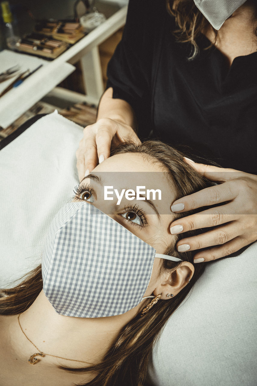 Beautician working with mask and protective screen for the virus covid