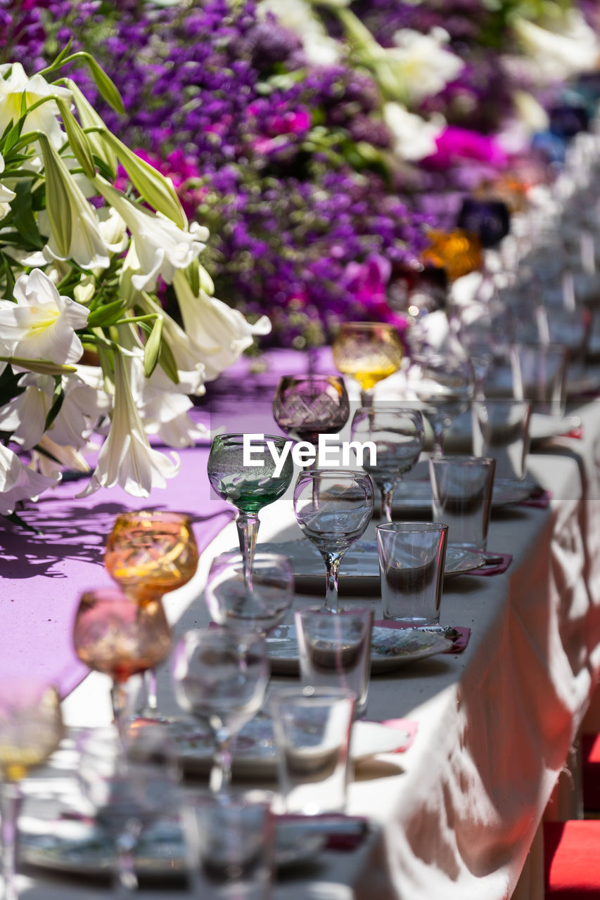 Laid celebration dinner table with empty beautiful tableware for holiday outdoor in summer sun day.