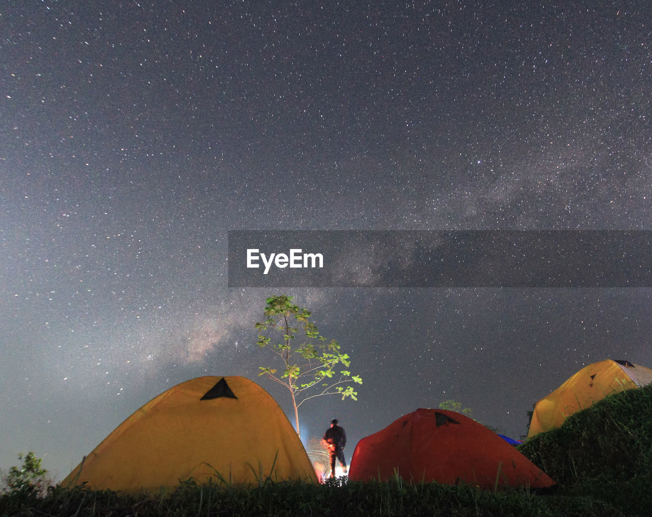 Low angle view of men standing against star field