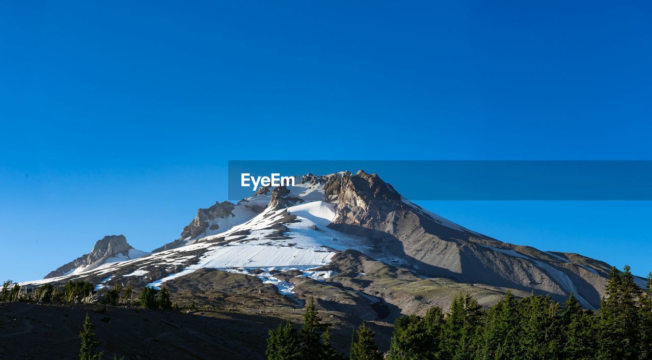 Low angle view of mt hood against clear blue sky