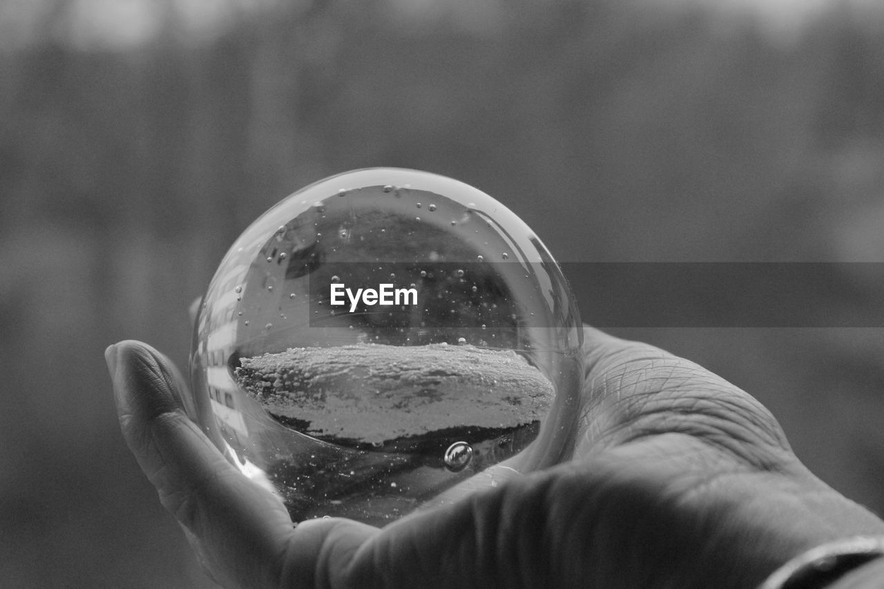 Close-up of hand holding crystal glass