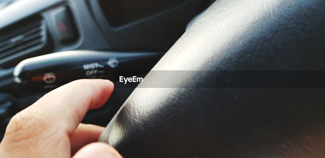 CLOSE-UP OF HANDS HOLDING CAR