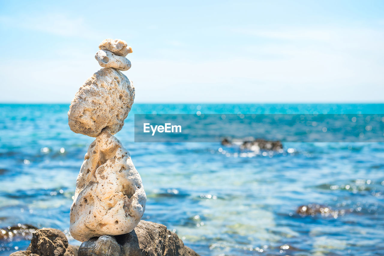 Zen stones balance at stony beach and sea background