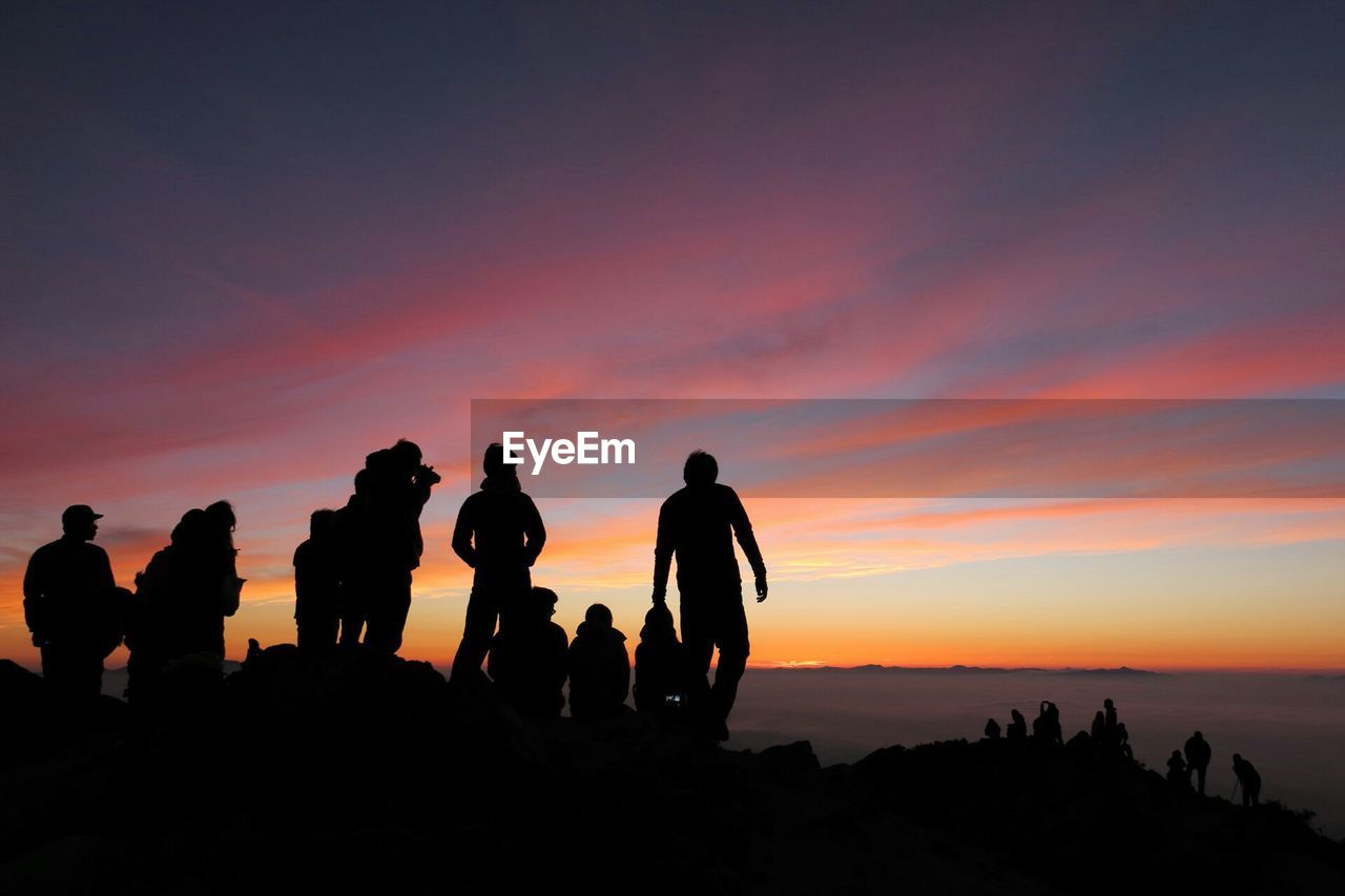 Silhouette of group of people on mountain