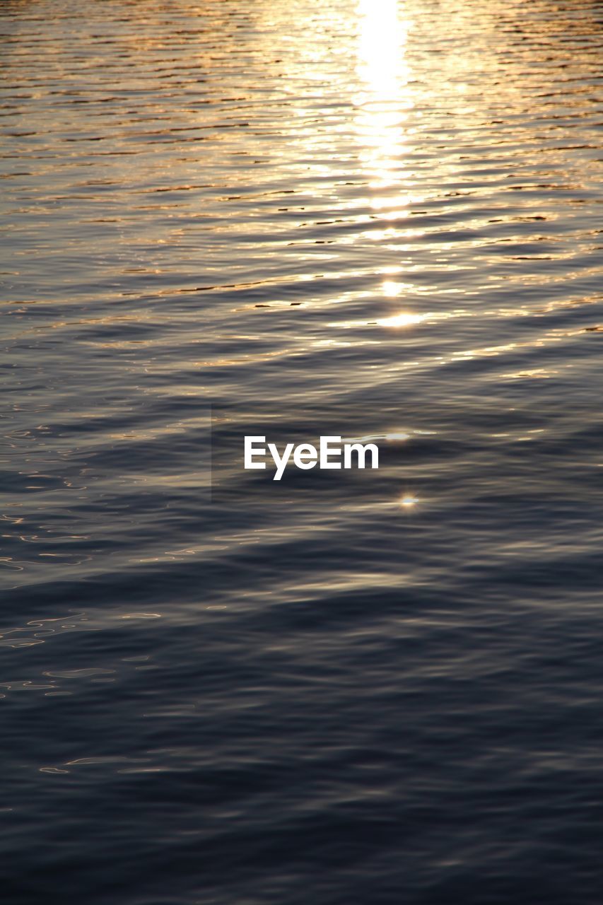 FULL FRAME SHOT OF RIPPLED WATER AT SUNSET