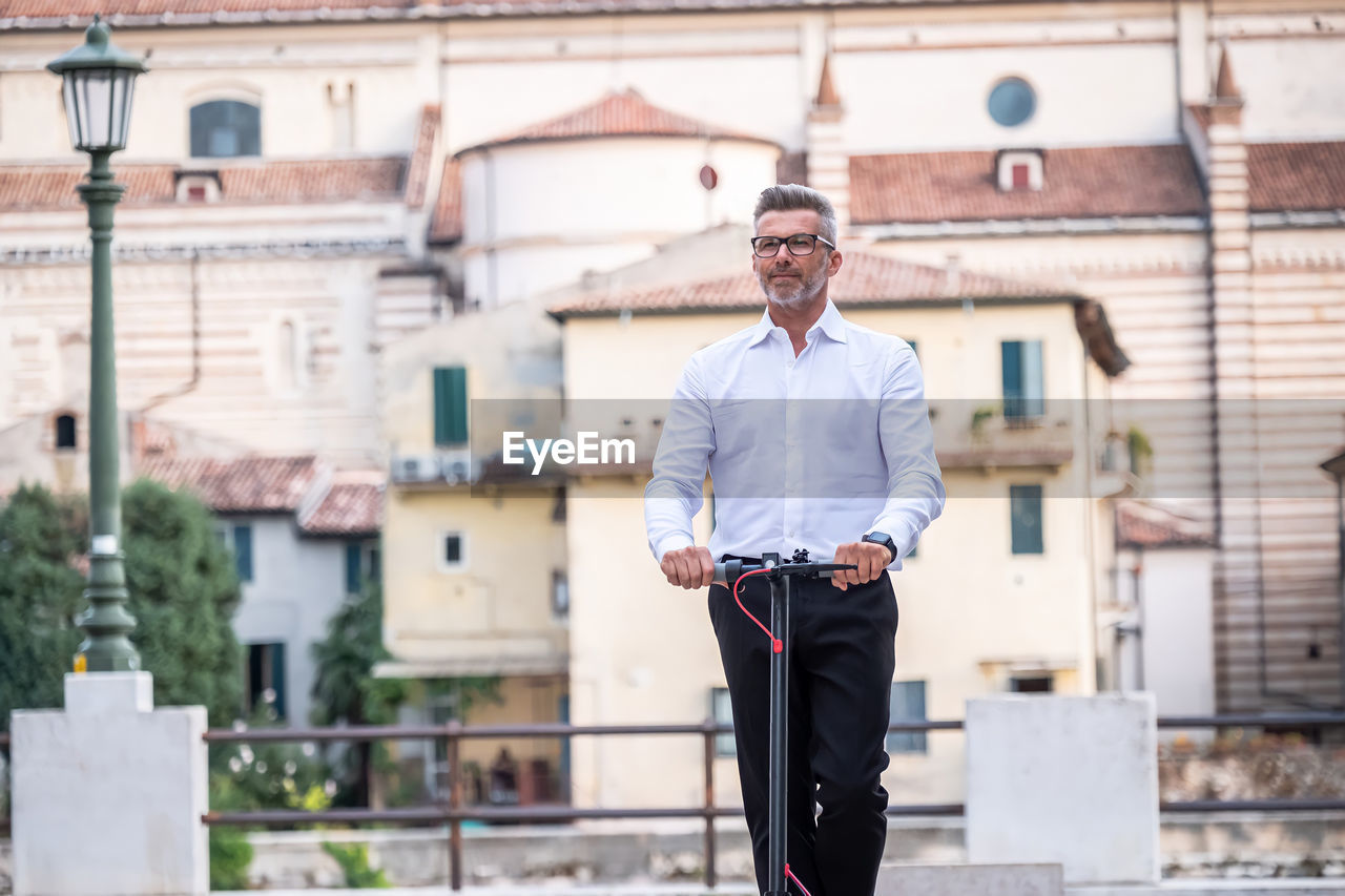 FULL LENGTH OF MAN STANDING ON BUILDING