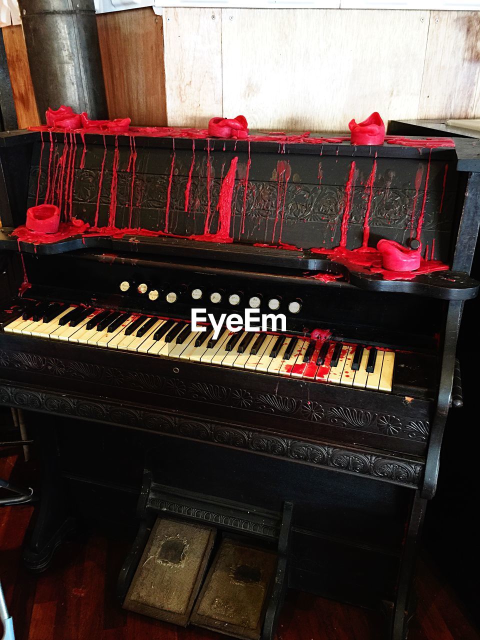 Melted red candles on antique piano