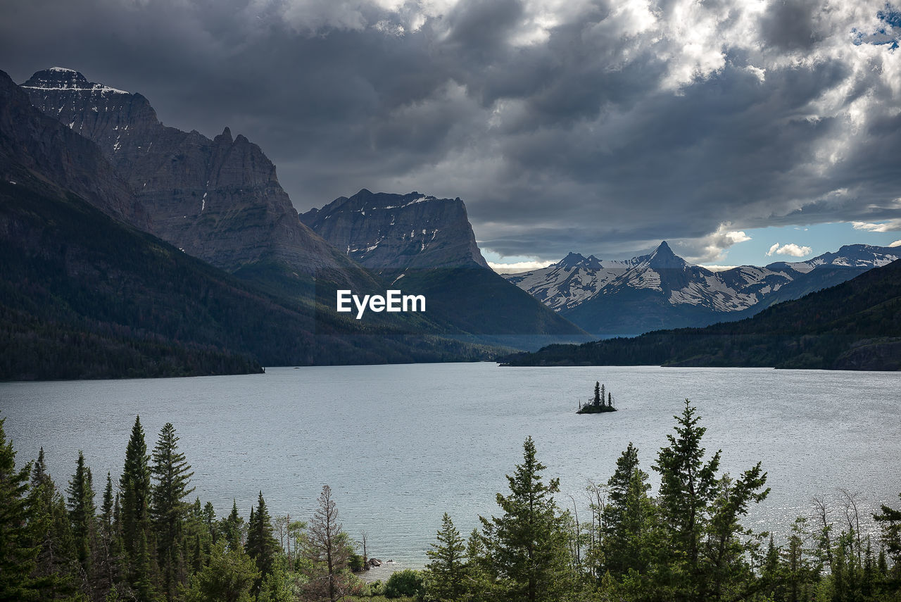 Scenic view of lake by mountains against sky