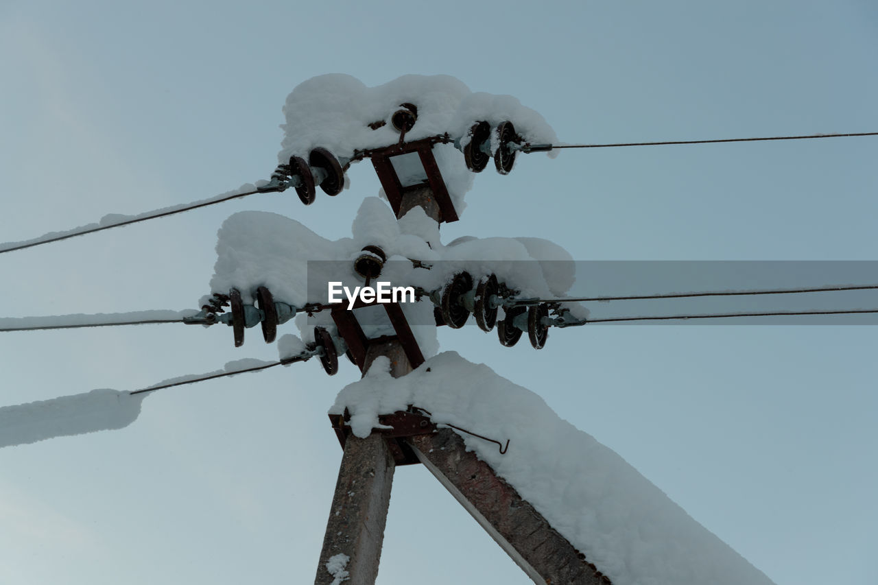 LOW ANGLE VIEW OF ELECTRICITY PYLON AGAINST CLEAR SKY