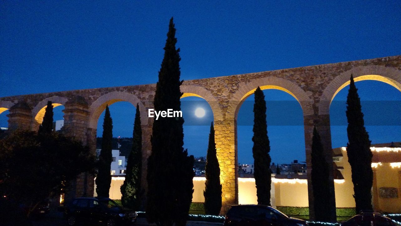 LOW ANGLE VIEW OF ILLUMINATED HISTORIC BUILDING AGAINST CLEAR BLUE SKY