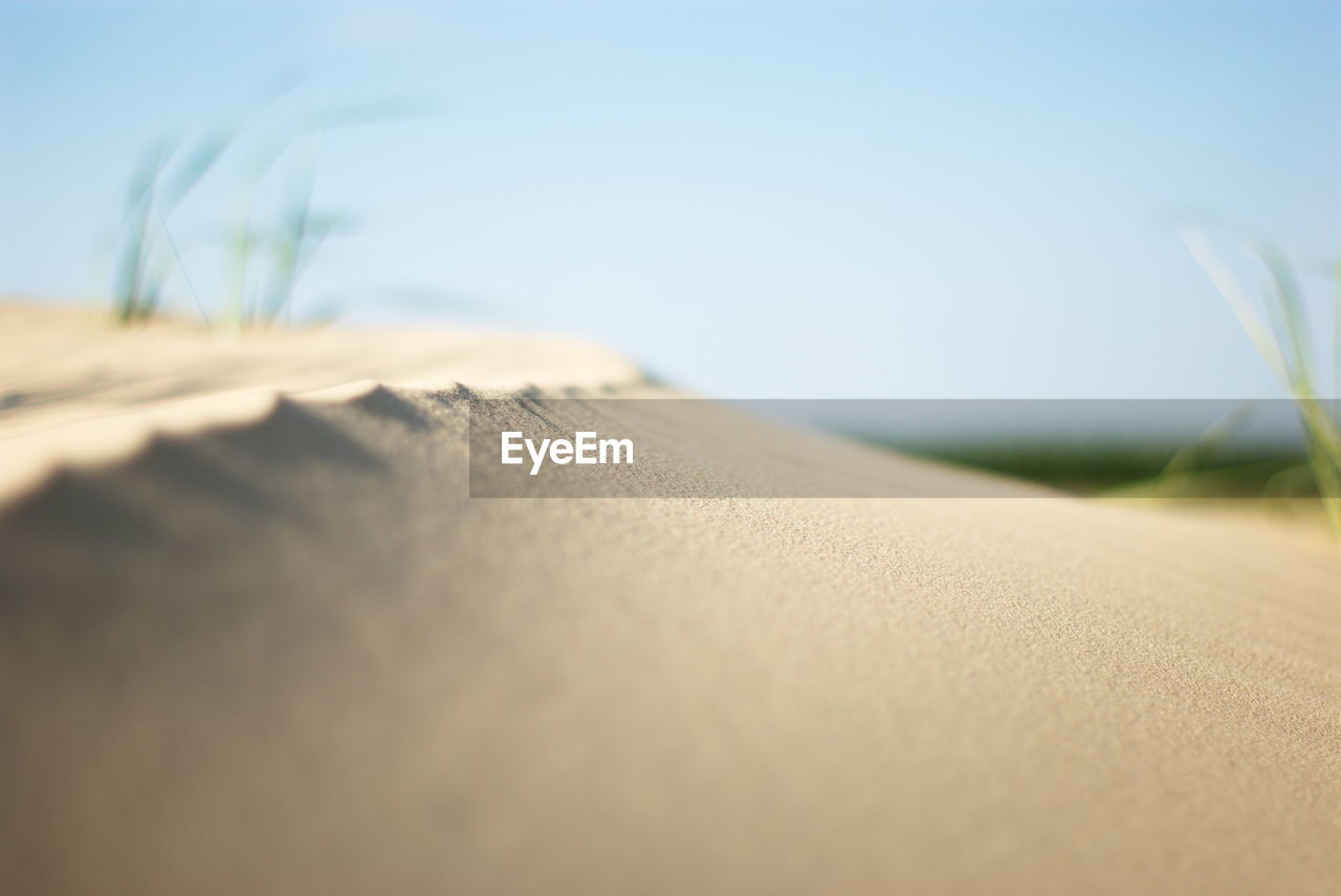 CLOSE-UP OF BOOK ON SAND AT BEACH