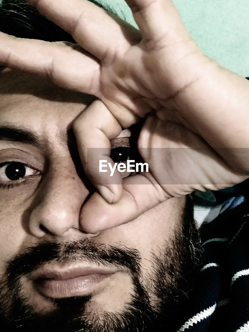 CLOSE-UP PORTRAIT OF MAN WITH HAND ON HUMAN FACE