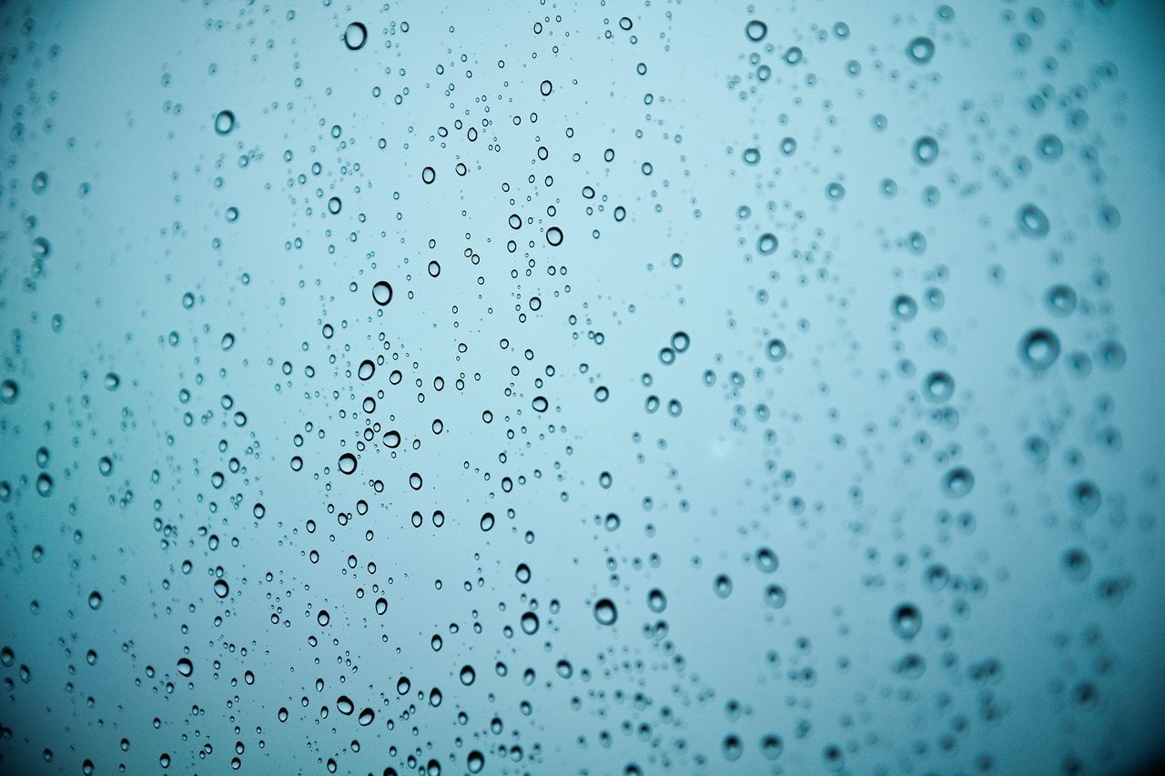 Full frame shot of water drops on glass window during monsoon