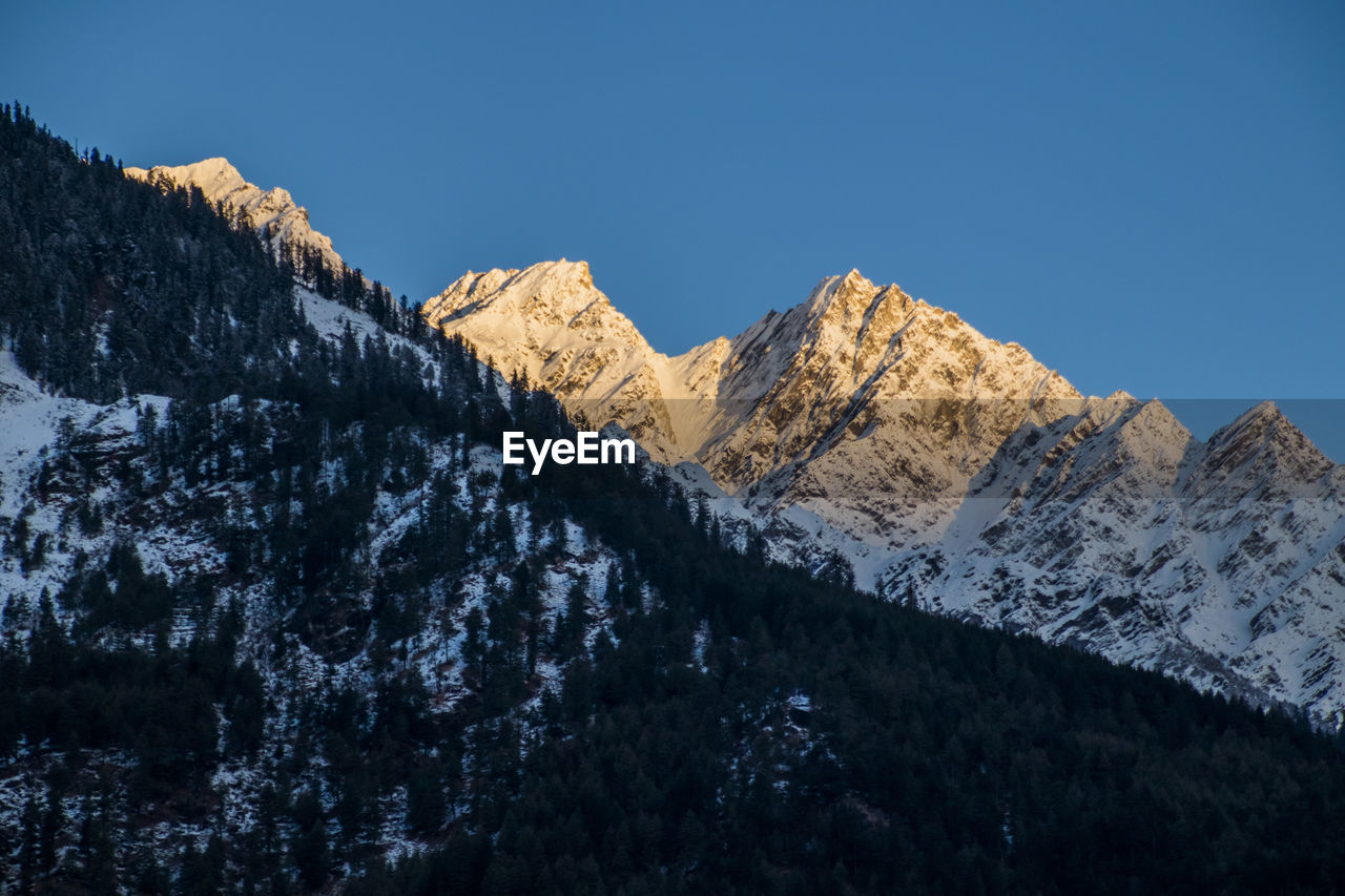 PANORAMIC VIEW OF SNOWCAPPED MOUNTAINS AGAINST CLEAR SKY