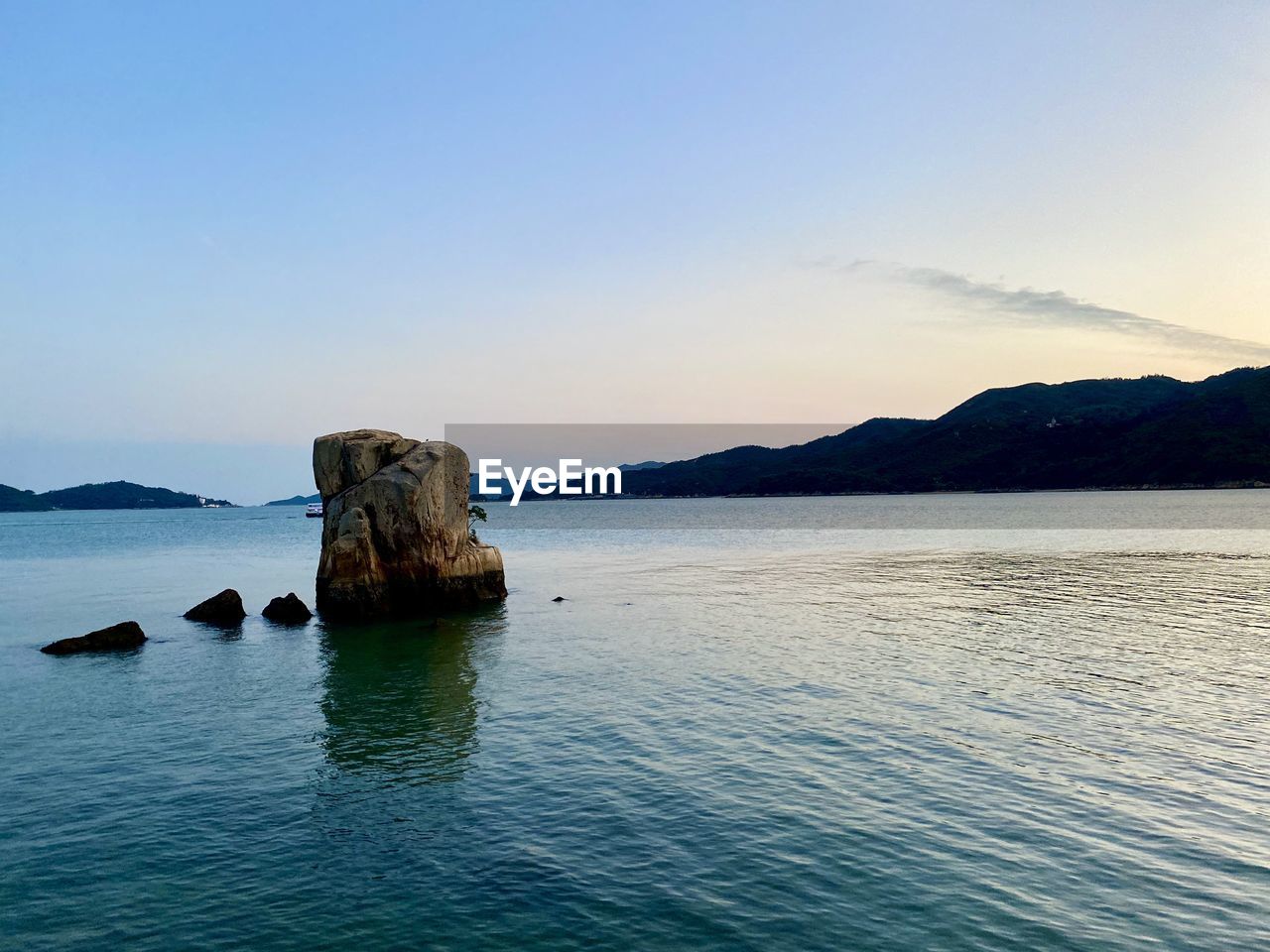 Rock formation in sea against blue sky