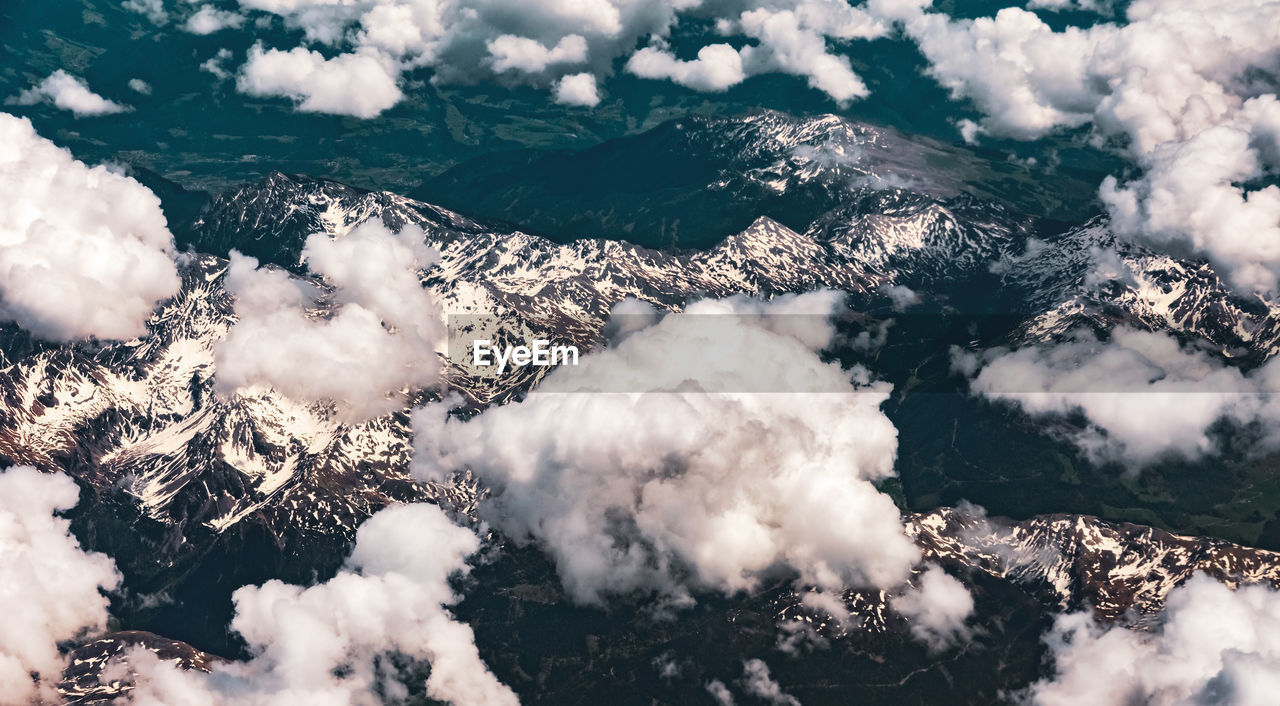 Aerial view of cloudscape over snowcapped mountains