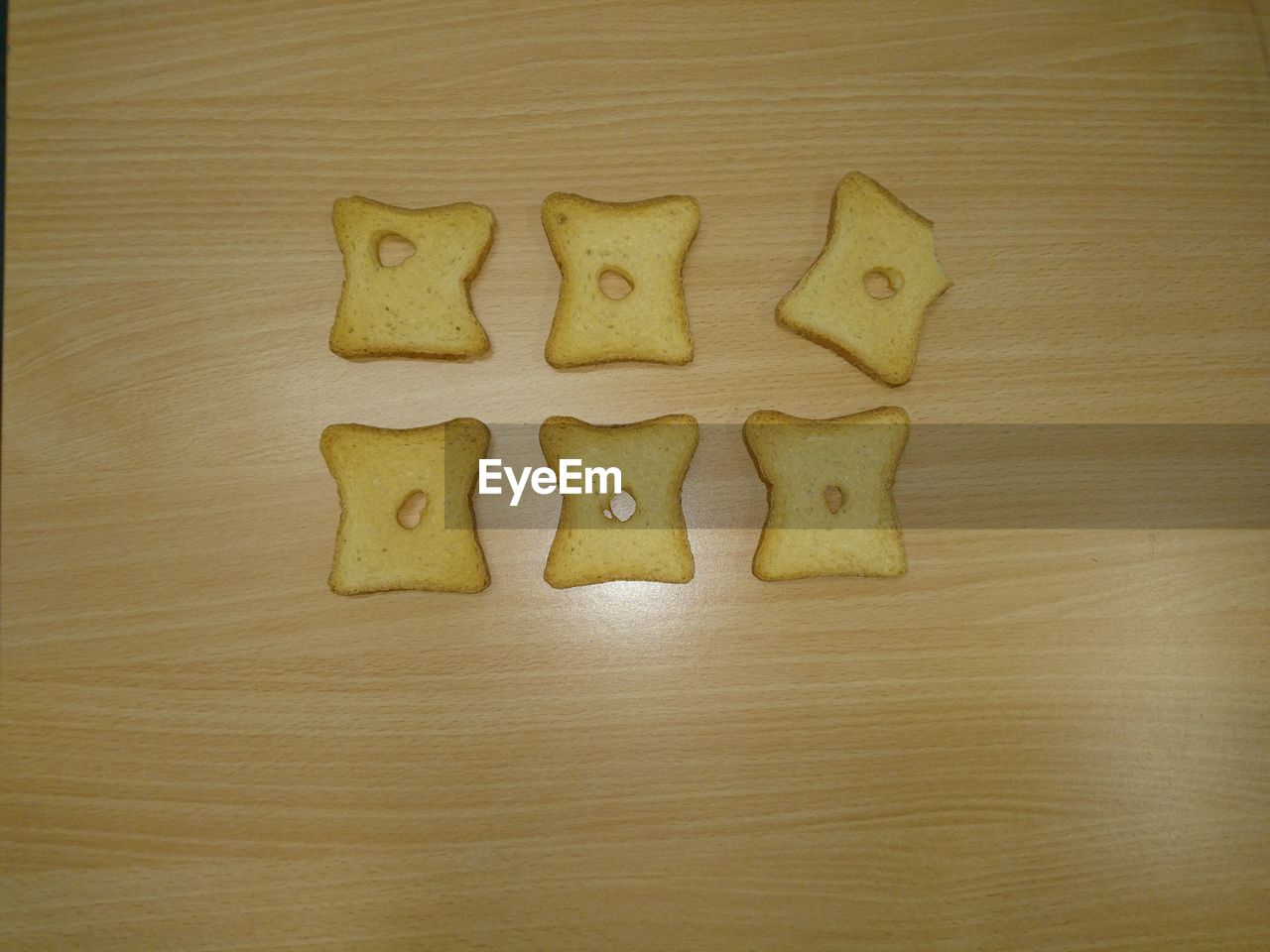 High angle view of holes in bread slices on table
