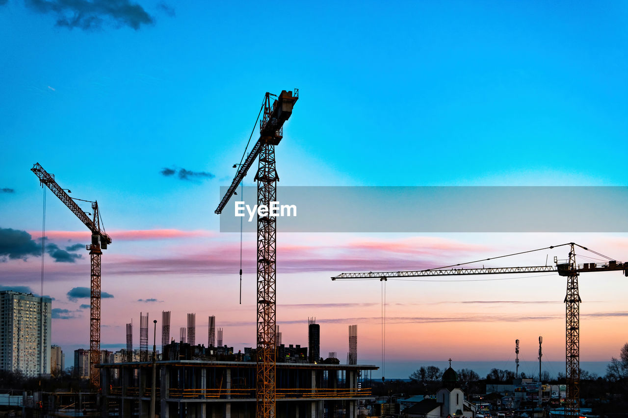 Construction site with crane. silhouette cranes, industry concept over natural background sunset 