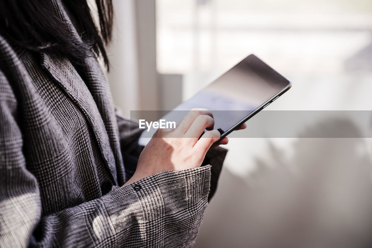 Unrecognizable business woman using digital tablet in office, co working, technology