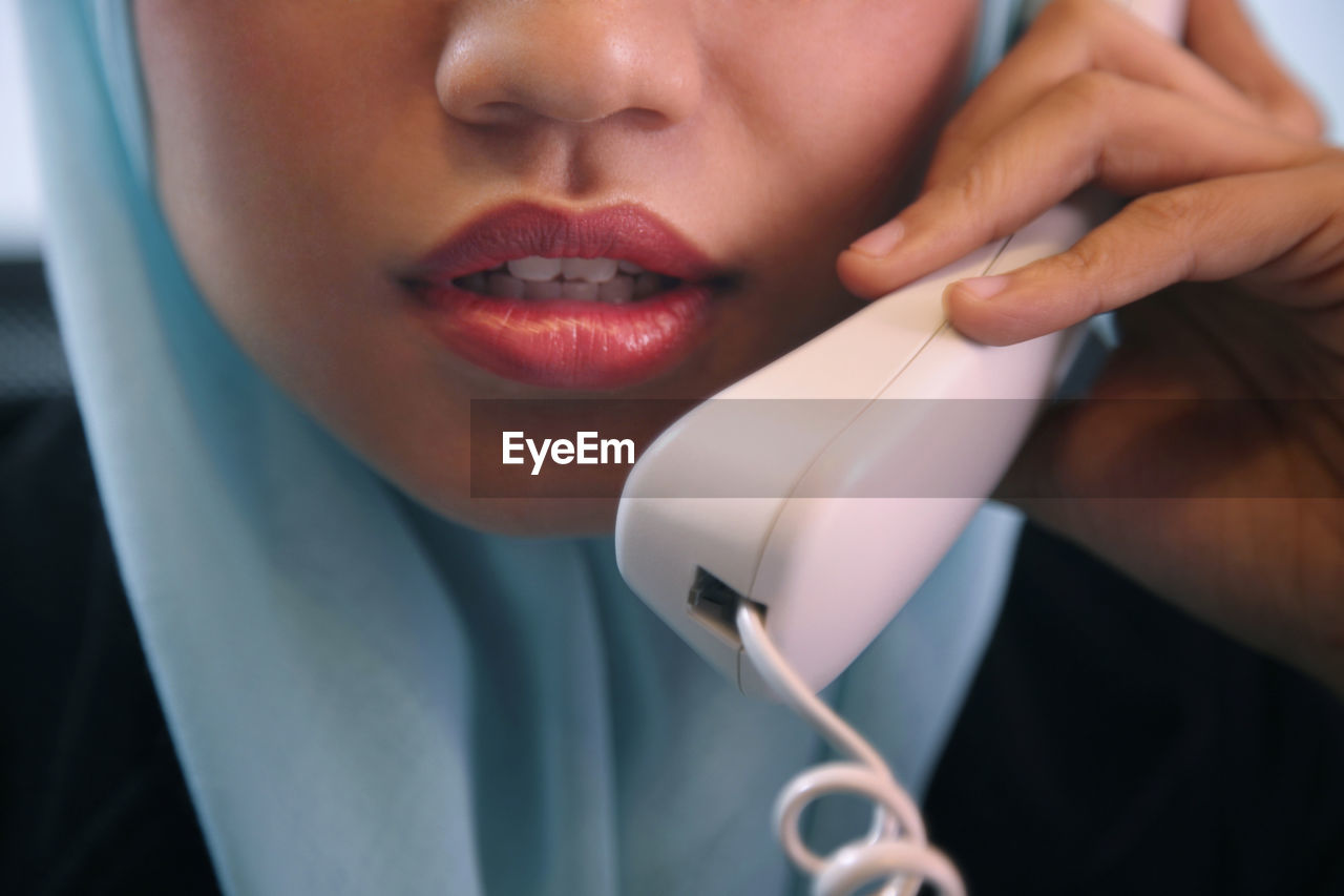 Cropped image of businesswoman talking on phone in office