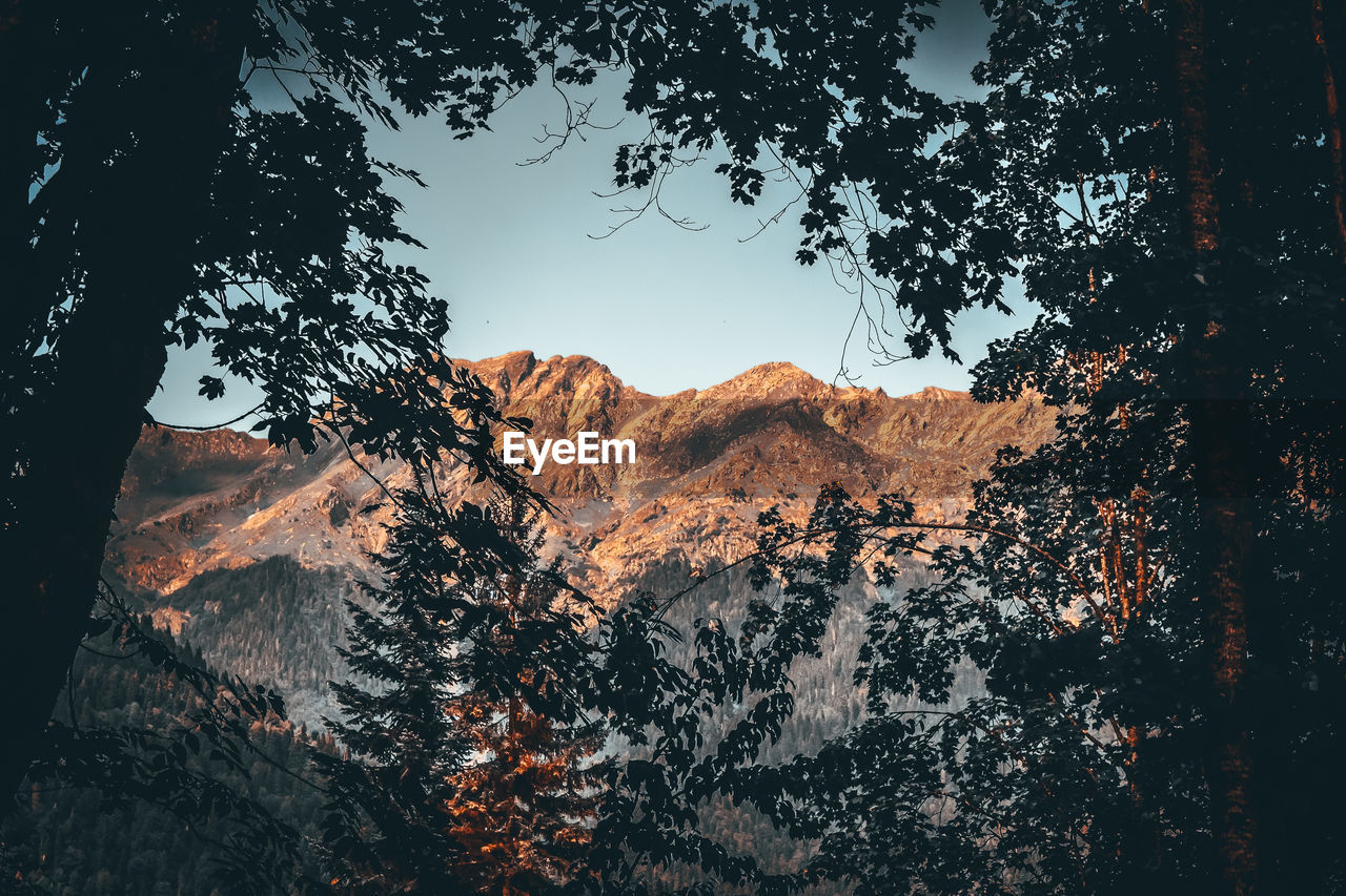 SCENIC VIEW OF MOUNTAINS AGAINST SKY AT SUNSET